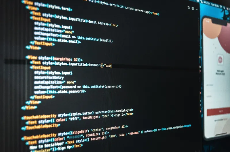 Close-up of code on a screen with a mobile login screen preview on the right