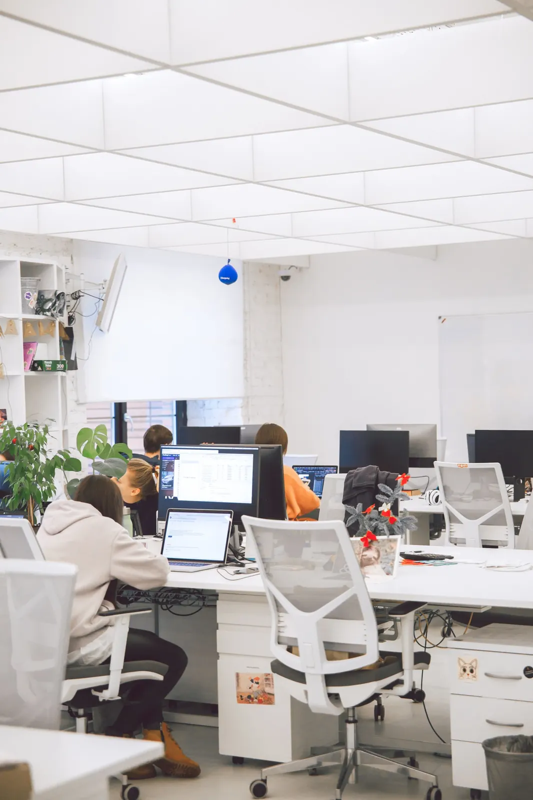 Bright open-plan office with people working at white desks