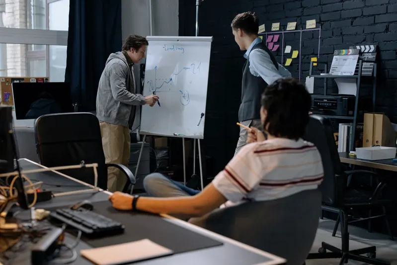 Team reviewing a testing chart on a flip chart in a studio